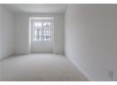 Unfurnished room with light colored carpet and baseboards
