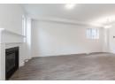 Unfurnished living room with dark wood-style floors and a glass covered fireplace