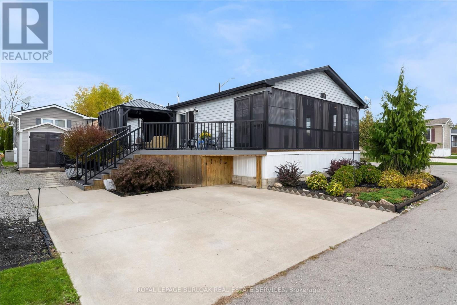 Standout Living in Lost Forest Park! Set yourself apart in this one-of-a-kind 2-bedroom, 2-bath modular home, offering a rare combination of cathedral ceilings, open-concept design, and resort-style living in Burlington's exclusive gated Lost Forest Park! Inside, the soaring vaulted ceilings create a bright and airy feel, while the stainless-steel appliances and thoughtful layout make everyday living both stylish and functional. With two full bathrooms, a crawl space for convenient storage, and even a generator for peace of mind, this home is designed with both comfort and practicality in mind!  Step outside to your very own retreat including a wrap-around porch with an inviting sunroom adding 147 sq. ft. of covered enjoyment year-round and overlooking the stunning gardens! Enjoy cozy afternoons in the charming gazebo or quiet evenings under the stars from your comfy deck! It's the perfect spot to unwind and take in the beauty of your surroundings.  It is a space designed for both relaxation and entertaining! Best of all, this home is set on a private corner lot, offering extra space, quiet surroundings, and enhanced privacy, making it one of the most desirable locations in the park! A handy storage shed adds extra functionality, while the double car driveway makes parking and manoeuvring a breeze! Beyond your doorstep, you'll enjoy all the benefits of Lost Forest Park living including a gated security, a seasonal pool, walking trails, community centre, and serene forested surroundings! With low land lease fees, this home is a fantastic choice for first-time buyers, downsizers, or those ready to travel and enjoy life without the stress of high maintenance! This isn't just another listing! It's a lifestyle upgrade in one of Burlington's most unique and welcoming communities! Don't miss your chance to call Lost Forest Park home where nature, comfort, and convenience come together beautifully! (id:48254)