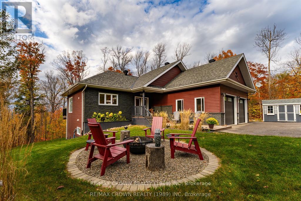 Nestled on scenic Ski Hill Ridge at the Powassan border, this meticulously crafted 3-bedroom, 3-bathroom home offers the perfect blend of modern comfort and natural beauty. Set on a private 1-acre cul-de-sac lot surrounded by mature maple forest, the property features seasonal views of Lake Nipissing and over 2,500 sq ft of finished living space. The pristine, landscaped grounds include a paved double driveway, a defined fire pit area, and a large storage shed offering both functionality and aesthetic appeal in a peaceful, woodland setting. Step inside to find a thoughtfully designed open-concept layout with soaring 9-foot ceilings throughout and a cathedral ceiling in the main living area, creating an airy, inviting atmosphere. The custom kitchen flows seamlessly into a spacious dining and living area with sliding doors that open to an elevated deck perfect for enjoying your forested backdrop in any season. A convenient two-piece powder room is tucked just off the main space, ideal for guests and everyday use. The primary suite offers a private retreat, complete with a walk-in closet, a luxurious 4-piece ensuite with a soaker tub and walk-in shower, and direct access to its own elevated deck ideal for quiet mornings or winding down under the stars. A generous mudroom/laundry room connects the home to a 24' x 24' insulated garage, making daily routines efficient and organized. Downstairs, the fully finished walkout lower-level doubles your living space and features a large open rec room, two additional bedrooms, a 3-piece bathroom, utility room, and ample storage. A full-length covered lower deck offers additional outdoor living space perfect for entertaining or simply enjoying the serene surroundings. Styled like a feature in a Muskoka lifestyle magazine, this home is both a tranquil retreat and a stylish full-time residence. Located just 10 minutes from Powassan and 30 minutes to North Bay, it delivers the best of Northern living with easy access to amenities. (id:48254)