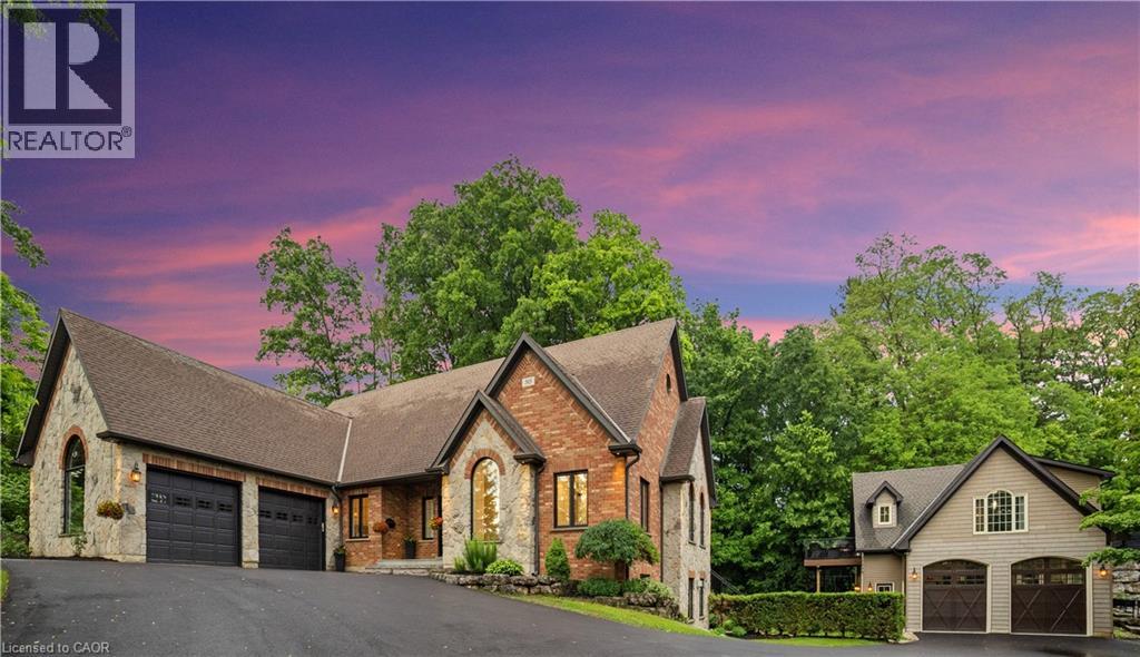 A rare find in Ancaster, this exceptional home sits on nearly one acre of private, wooded land, offering a serene and secluded setting while remaining just minutes from premier amenities and convenient highway access. The expansive lot offers ample space for a pool or additional outdoor features, blending luxury with nature and privacy. With over 5,100 square feet of total living space, this impressive residence features 8 bedrooms, 6 bathrooms, 3 full kitchens, 3 laundry facilities, and 5 gas fireplaces—perfectly suited for executive living, small business owners, or multi-generational families. No need to escape to a cottage for calm and tranquility as it’s all out your back door.  Incredible Muskoka tree rich feel privacy with no visible neighbors off the large back deck, this property really has to be seen to feel the class, calm and comfort that is seeped through it.   Despite its generous size, the property is surprisingly low-maintenance thanks to beautifully designed perennial gardens and the natural landscape of the wooded lot. The main home has been thoughtfully and artistically remodeled with a rustic, contemporary design, showcasing high-end finishes throughout. The in-law suite enhances the home's flexibility and includes 2 bedrooms, 1 full bathroom, a modern kitchen with stainless steel appliances, laundry facilities, and its own private living space. A standout feature on the property is the custom detached garage, equipped with a hoist, extensive cabinetry, and a full workshop setup. Above the garage, you'll find an additional 887 square feet of living space that serves beautifully as a guest house or second in-law suite, complete with 2 bedrooms, 1 bathroom, a modern kitchen with stainless steel appliances, laundry facilities and deck. This is a truly one-of-a-kind offering in Ancaster that won’t last long.  Book your private viewing today—because once you see it, you’ll want to make it yours. (id:48254)