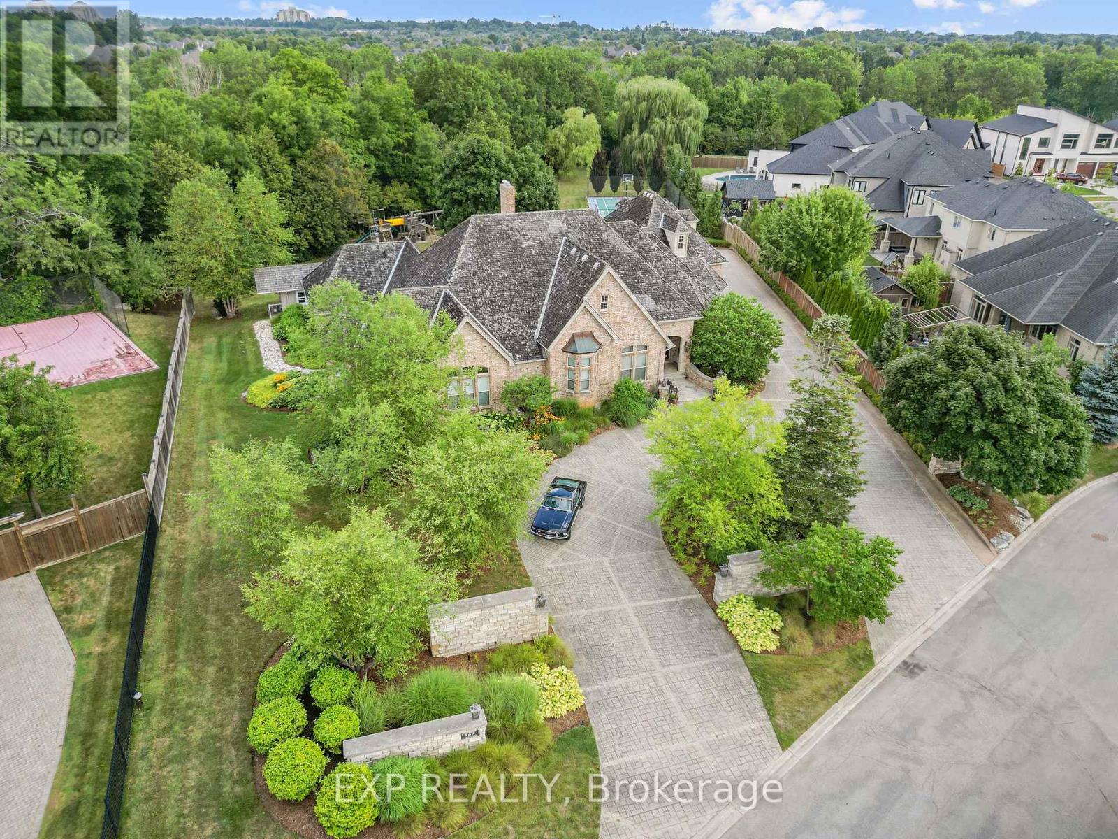 Custom-built estate just under 7,000 sq. ft., this one-of-a-kind residence backs onto the Medway River and was awarded Ontario's Custom Home of the Year upon completion. Tucked away on one of North London's most prestigious streets, the home sits on nearly an acre with a stamped horseshoe concrete drive leading to the triple car garage. Inside, timeless craftsmanship is evident with rich woodwork throughout, a formal living room with wood-lined ceilings, custom built-ins, and ambient lighting. The main floor offers four bedrooms, with two additional potential bedrooms upstairs, along with a wood-paneled office, a custom gym above the garage, and an extra family room above the billiards room. The spacious eat-in kitchen opens to a sunroom and screened patio, while heated flagstone walkways and patios flow to a fully reimagined backyard oasis. The exterior was completely redesigned with professional landscaping, custom stone sills, outdoor lighting, power screens, a multi-sport court that converts to a winter rink, a custom all-season hot tub spa, and an outdoor bathroom with oversized equipment room designed for a future infinity pool. Bellissimo light fixtures, a 19-zone irrigation system, and invisible fencing complete the grounds. The primary suite features its own living room and private courtyard, while all bathrooms were fully redesigned between 2012-2014 with luxurious finishes. Comfort upgrades include spray-foam insulation, a newer HVAC system, and a state-of-the-art Elgin Pure Water purification system. Modern technology abounds with Savant whole-home automation, Legrand touch switches, motorized roller shades, a 12-camera security system, and an integrated outdoor sound system.Blending award-winning design with extensive updates, this estate offers unmatched privacy, sophistication, and lifestyle truly one of Londons most distinguished residences. (id:48254)