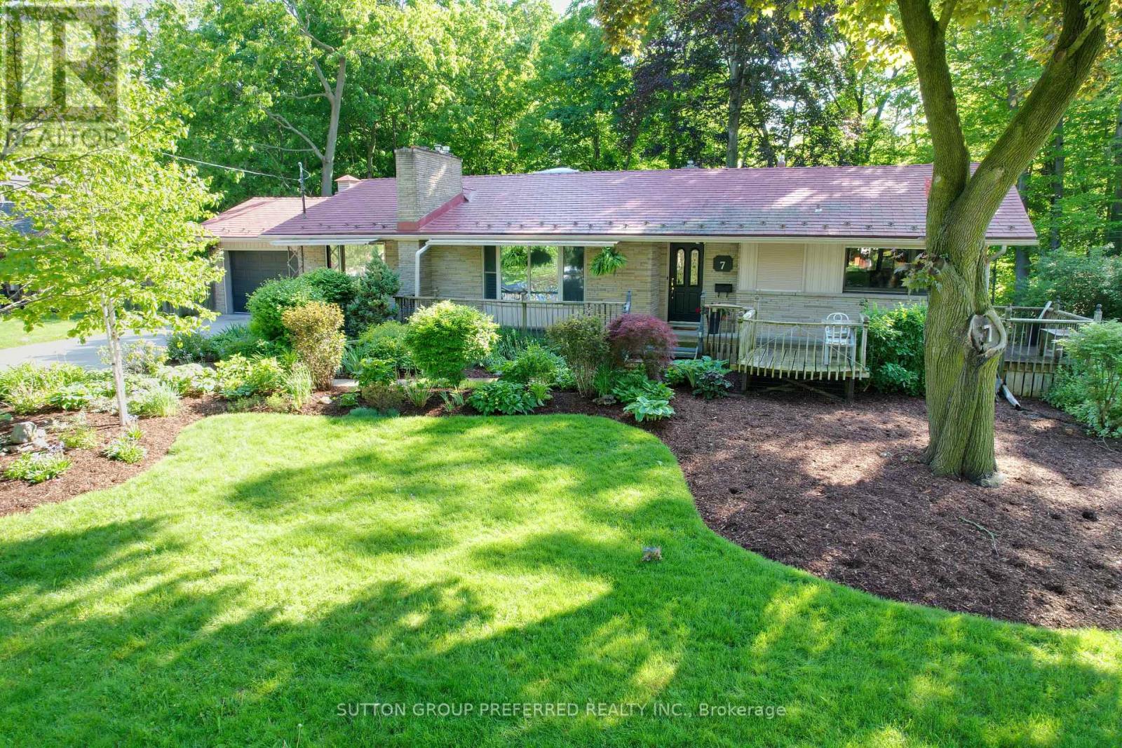 Nestled in the executive area of the Sherwood Forest neighbourhood, this distinctive stone-faced home offers a rare blend of country charm and modern comfort. Set on a beautifully landscaped 100-foot lot backing onto a serene wooded ravine, this 5-bedroom, 4-bathroom residence is perfectly suited for families and avid entertainers alike, with over $150,000 in recent renovations and upgrades.The main level showcases original oak hardwood flooring and features a spacious living room with a gas fireplace, formal dining room, and a warm family room with a second fireplace, seamlessly open to the kitchen. A sun-filled sunroom with skylights and stunning 180-degree ravine views provides a tranquil space to relax year-round. Two bedrooms are located on this level, including the primary suite. Many windows are equipped with exterior insulated roll shutters for added comfort and efficiency. The fully renovated lower level (2022) offers exceptional additional living space, featuring three generous bedrooms, a stylish 4-piece bathroom, and a large recreation room with a third fireplace. Extensive upgrades include updated insulation, new windows, professional waterproofing, and a new sump pump. Outdoor living is equally impressive, with a spacious 32-foot deck overlooking the ravine and a 40-jet Hydro hot tub-ideal for unwinding or entertaining. Additional highlights include a lifetime-warrantied interlocking metal roof, reclaimed heritage pine woodwork throughout, and an oversized double garage complete with workshop. Located just minutes from Western University, Medway Valley Trails, parks, and top-rated schools, this exceptional home offers a perfect balance of nature, luxury, and everyday convenience. (id:48254)