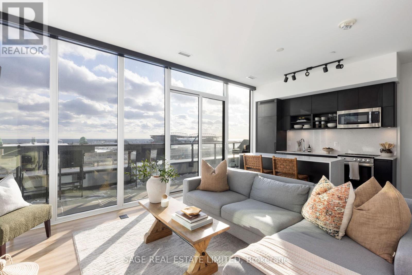 Welcome to Toronto's West End - where urban sophistication meets waterfront living in Liberty Village. This corner 3-bedroom + den residence at 135 East Liberty offers an unparalleled lifestyle opportunity with breathtaking unobstructed lake views from its expansive south-east wraparound terrace.  Built in 2021, this modern suite showcases thoughtful design throughout - from 9-and-a-half-foot ceilings and floor-to-ceiling windows without bulkheads, to engineered hardwood floors and sound-attenuated windows that create a peaceful sanctuary above the city. The intelligent layout maximizes privacy with most walls unshared with neighbours.  The chef's kitchen features premium finishes including quartz countertops and backsplash, custom island, stainless steel appliances (integrated fridge/dishwasher), and soft-close cabinetry. Adjacent custom bar area with beverage/wine cooler and built-in console creates the perfect entertaining space.  Three generous bedrooms include a primary suite with south-facing lake views, terrace walkout, and 4-piece ensuite. The versatile second bedroom functions perfectly as a home office for work-from-home professionals. Corner third bedroom boasts eastern city views through a wall of windows.  Premium building amenities (gym, party room, rooftop terrace, communal BBQs, shared workspace, concierge), one indoor parking spot,  and a premium locker (close to parking space - huge bonus). Steps to Trinity Bellwoods, King West entertainment, Liberty Village dining, and waterfront trails. Easy access to Gardiner/DVP, Exhibition GO and Waterfront Streetcar loop, for commuters moving to the city.  Maintenance: $1,035.32 includes heat, cac, common elements, internet and building insurance. (id:48254)