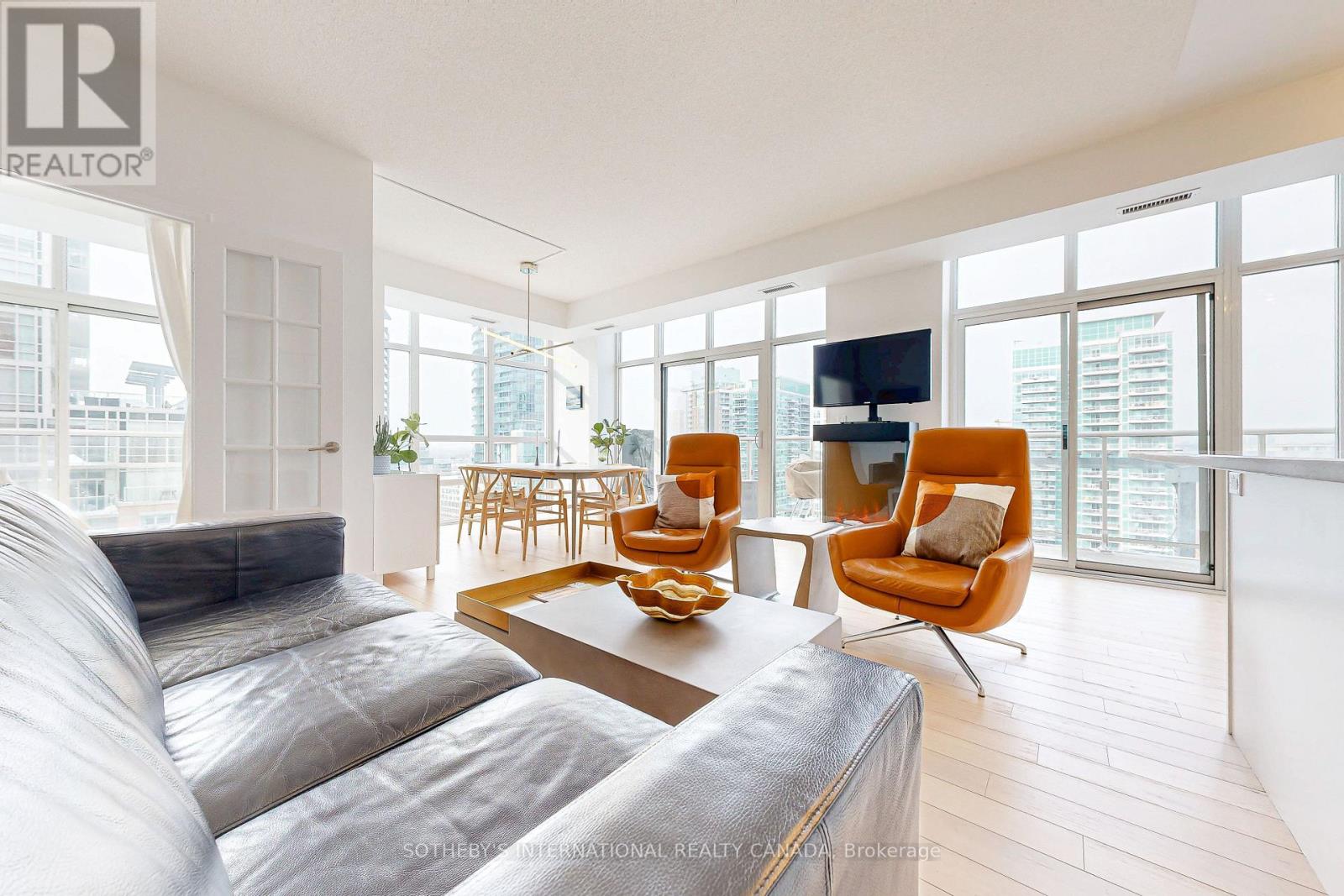 Exceptional Liberty Village Corner Residence - Rare 3 Bed with Dual Balconies. This Beautiful Oversized corner suite in King West Condos offers 1450 sqft of living space (1228sqft inside & 222 sqft outside), thoughtfully upgraded and impeccably maintained. This unique residence features 9ft Ceilings a luminous open layout with light-engineered hardwood floors, beautifully uplifted white cabinetry in the kitchen and bathrooms, and a serene Danish minimalist aesthetic. Enjoy expansive indoor-outdoor living with 2 seperate balconies and captivating city & lake views - perfect for enjoying a coffee or evening entertaining where you can BBQ directly on your Terrace. Generous primary bedroom with walkin wardrobe and vast 5 piece ensuite with seperate shower and soaker bath, tjis bedroom has space a lounger where the owners like to site and read. Great sized west facing Secondary bedroom and storage and generous guest batroom with large walkin shower, directly opposie. A standout feature is the flexible third bedroom/office, enhanced by the current owners with a built-in Murphy bed, custom storage, a privacy curtain, via glass doors from the living room, and then a direct walkout to a balcony. The smart layout maximises space and functionality without compromise, with abundant storage, and premium finishes elevate everyday living. Meticulously kept with clean European furnishings, you will think it has been staged. Residents enjoy an extensive suite of amenities, including a fully equipped gym, indoor pool, golf simulator, bowling alley, theatre and party rooms, steam room and 5 guest suites in the building - creating a lifestyle beyond the typical condo experience. Included a locker that backs directly onto one private parking space and a new bike rack installed by the owners. This is a rare opportunity to own a large, sophisticated urban home - a standout residence in a competitive condo market. (id:48254)