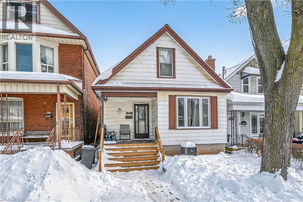 Affordable, move-in-ready 1.5-storey home ideal for first-time buyers. Offers 3 bedrooms (one on the main floor) and 2 bathrooms. Renovated eat-in kitchen (2022) with ample cupboard space and all appliances included. Main-floor bath with laundry also completed in 2022 along with main floor flooring. Furnace, central A/C, and owned water heater all less than 5 years old. Full unfinished basement with large cold room and walk-up to rear yard is full of potential. Covered front and rear porch. Rear lane paved driveway with parking for up to 3 cars. Convenient Central Hamilton location close to transit, schools, and shopping. (id:48254)