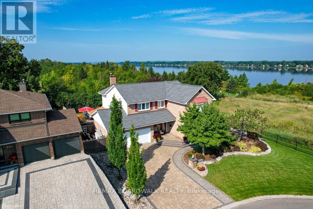 Set on a quiet cul-de-sac in the established enclave of Convent Glen North, this distinguished residence is defined by privacy, mature landscape, & sweeping views toward the Ottawa River while bordering protected NCC green space. Wrought iron fencing, interlock approach, & sculpted architectural planting create a composed arrival, leading to twin glass entry doors & a gracious foyer anchored by a curved staircase & site finished hardwood flooring throughout the principal level. The interior balances openness w/intention. A thoughtfully designed kitchen features quartz surfaces, refined cabinetry, integrated lighting, bay window seating, & a wall of pantry storage w/glass detailing. The adjacent dining room, framed by crown moulding, opens through wide patio doors to an elevated stone terrace oriented toward river & forest views. A sunken living room centred on a sculptural gas fireplace & a separate family room w/stone hearth & corner windows provide inviting spaces for gathering & quiet retreat. A discreet powder room & service access connect seamlessly to outdoor entertaining areas including barbecue terrace & hot tub patio. Upstairs, the primary suite offers morning river views, a three sided fireplace, expansive glazing, & a full wall of custom storage. The spa inspired ensuite presents a freestanding tub, dual vanities, radiant heated flooring, & a generous glass shower. Additional bedrooms are well proportioned & served by a refined main bath finished in travertine with oversized walk in shower. The lower level extends living w/a multifunctional recreation space, wet bar, private den, secondary powder room, & dedicated laundry. Outdoors, forested privacy surrounds a heated saltwater pool & architectural hardscape designed for relaxation & entertaining. Walking distance to river pathways, transit, future light rail, shopping, & schools, this home offers a rare balance of natural seclusion & urban convenience, 24 Hour irrevocable on all offers. (id:48254)