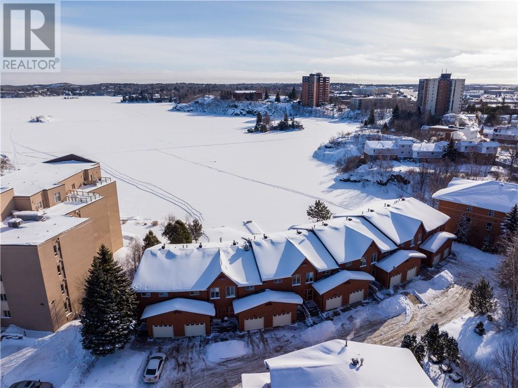 Waterfront living meets modern comfort at Unit 11 – 1848 Paris Street, a beautifully renovated, one-owner condominium with breathtaking views of Lake Nepahwin. This spacious 3-bedroom, 2 full + 2 half-bath home is tucked within a quiet, well-maintained complex just minutes from the heart of the city. Thoughtfully upgraded throughout, it offers the perfect blend of timeless design and modern finishes. Sun-filled rooms and expansive windows beautifully frame the lake, filling the home with natural light and showcasing the incredible waterfront scenery. The open-concept living and dining areas flow seamlessly to a private deck; an ideal setting to unwind, entertain, and take in stunning sunsets over the water. An attached garage with convenient interior access adds everyday functionality, while the pride of original ownership is evident in every detail. With its solid layout, stylish updates, and unbeatable location, this is a rare opportunity to enjoy turnkey waterfront living in one of Sudbury’s most desirable areas. Book your private tour today! *One or more photos have been virtually staged to illustrate the homes potential.* (id:48254)