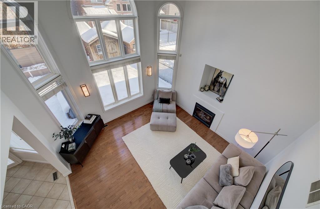 Discover this stunning, SMART family home in the prestigious River Ridge at Kiwanis Park, where elegance, space and natural light come together beautifully. From the moment you step inside, the grand foyer sets the tone with an impressive view of the open-concept layout and striking central hardwood staircase.  The thoughtful floorplan offers exceptional flow throughout the main level. Soaring ceilings and floor-to-ceiling windows fill the home with an abundance of natural light. The formal living room opens seamlessly to a dining room large enough to comfortably host twelve—perfect for family gatherings and celebrations.  At the heart of the home is an oversized chef’s kitchen, featuring stainless steel appliances, a newer gas stove (Dec/24), a centre island with built-in wine fridge, and a bright dinette with sliding doors that lead to a stone patio, beautiful wall garden and fully fenced backyard. The adjoining family room is designed for entertaining, offering generous space, an 18-foot ceiling, and a cozy gas fireplace that adds warmth and sophistication. Upstairs, upgraded maple hardwood flooring flows throughout. The luxurious primary suite boasts a spacious walk-in closet and a spa-inspired 5-piece ensuite. Three additional bedrooms are generously sized with excellent natural light, including a guest bedroom with convenient cheater access to the shared bathroom. The lower level offers outstanding potential, featuring large windows and a roughed-in bathroom—ready for your personal vision. Upgraded electrical panel (2022) to incorporate EV charging! Ideally located steps from Kiwanis Park, the scenic Grand River trails, and lush greenspace, and just minutes to top-tier schools and essential amenities, this home truly has it all. (id:48254)