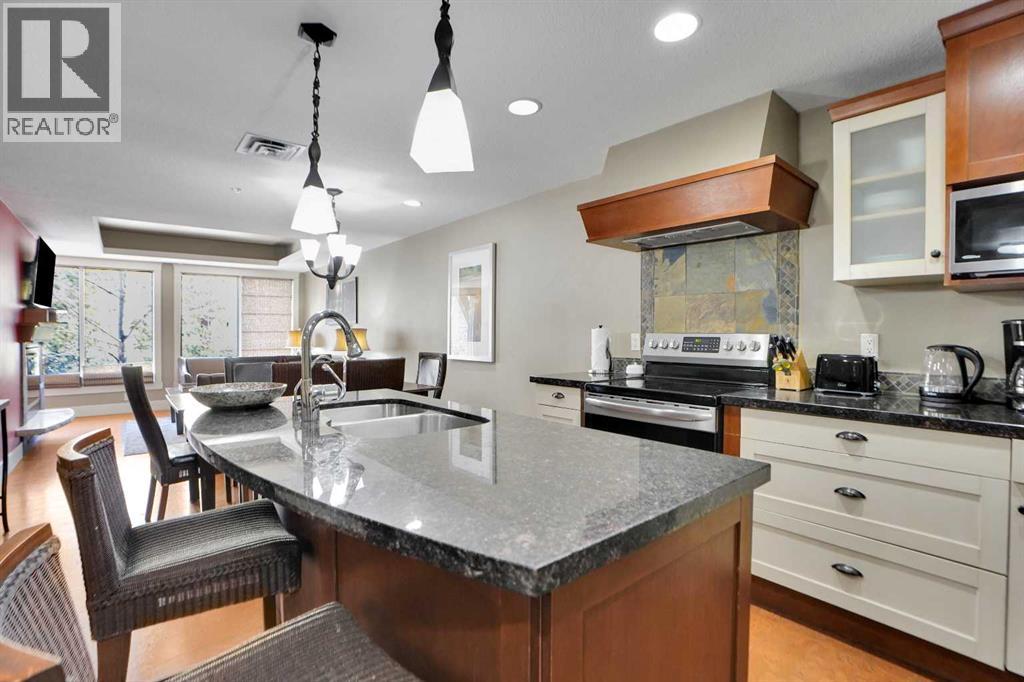 As the only active listing with this specific floorplan, the interior features premium finishes including European cork flooring, premium appliances, and custom granite and polished concrete countertops. The two spacious bedrooms are each accompanied by a spa-caliber ensuite featuring soaker tubs and rain showers. The massive private L-shaped balcony is equipped with a gas grill and is accessible from both the living area and the primary bedroom. Guests can enjoy access to a comprehensive suite of world-class amenities: a professional-grade fitness centre, wellness spa, physiotherapy clinic, pool, hot tub and on-site conveniences such as a cafe and a liquor store. Practical additions include underground parking, large storage lockers, and a dedicated ski waxing room. This unit boasts a flexible blend of luxury living and a premier investment opportunity for high-yield income potential. (id:48254)