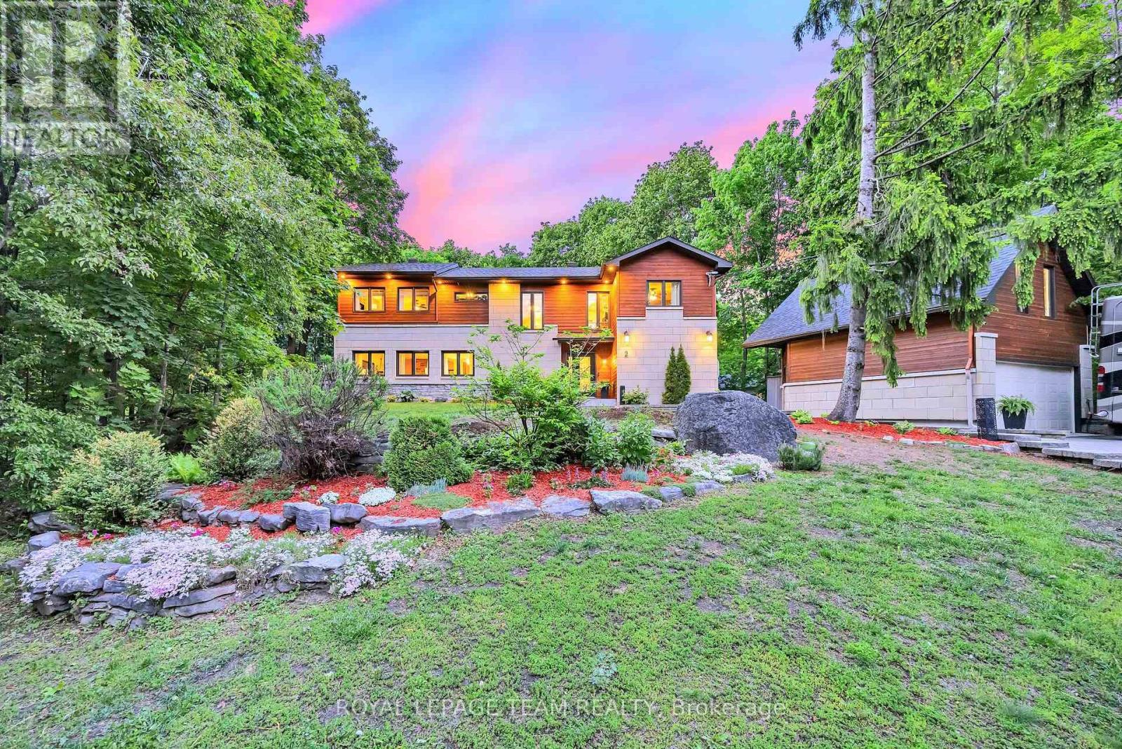 A rare opportunity to own a private country home in the city. This impeccably updated mid-century classic in highly sought-after and historic Fairhaven, is perched on a breathtaking half-acre wooded estate lot offering unmatched privacy in a serene, nature-immersed setting. Tucked away on a safe, quiet street, surrounded by towering trees, you're a short walk to the Montfort Hospital, CMHC, NCC pathways and only minutes by car to downtown. This residence has been transformed top-to-bottom with designs and finishes that blend modern comfort with timeless architectural character. Every space has been tastefully curated to ensure warmth, functionality and sophistication. The exquisite chef's kitchen with large quartz island and pantry opens to the spacious, bright dining area and living room with it's original 1950's stone hearth, a cozy/practical wood stove and patio access. To the right of the impressive entrance-way is the main floor bedroom (now serving as a gym). With an adjacent bathroom and family room, it's the perfect nanny or in-law suite. At the top of the stylish staircase, there's a bright landing, perfect as an office space. The second floor East wing has two spacious bedrooms, one with deep double closets, the other with a full walk-in. The family bath contains a convenient 2nd floor laundry. At the West end of the hallway is the expansive primary bedroom with 5-piece en-suite bath and spacious walk-in closet. Designer finishes on both levels include pot lights, quality fixtures, high-end appliances, fine ceramic tiles and rich maple hardwood throughout. Spend countless evenings outdoors on the stone patio with a fire pit. The large 2-car garage has a 2nd floor with tons of storage space and the triple-wide interlock driveway provides plenty of parking for all your cars and toys. Homes of this calibre, combining estate-style tranquil enclave living, architectural excellence and exceptional proximity to urban amenities, are seldom available in Ottawa. (id:48254)