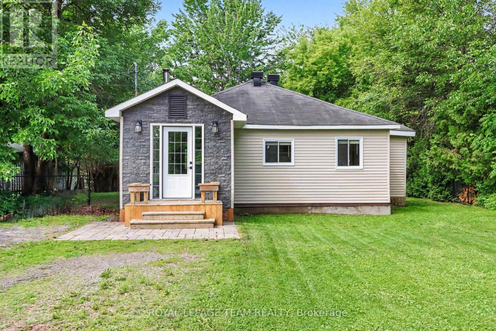 Escape to the tranquility of waterfront living while enjoying the convenience of being just minutes from Kemptville. Nestled directly on the water and across from  beautiful & tranquil Ferguson Forest, this charming 2-bedroom home offers the perfect blend of comfort, nature, and year-round enjoyment. The bright and welcoming foyer leads directly to the kitchen, which features ample cabinetry and generous counter space-ideal for cooking, entertaining, and everyday living. The open-concept living room is filled with natural light and showcases stunning waterfront views. Easy-care laminate flooring and a WETT-certified wood-burning fireplace create a warm and inviting atmosphere for every season. From the living room, step outside to relax on the covered porch or entertain family and friends on the  two-tiered deck. With your own dock, you have direct access to launch a canoe, kayak, or boat and fully embrace the waterfront lifestyle. The primary bedroom offers ample closet space and convenient access to the laundry room as well as a versatile den-perfect as a home office, reading nook, or hobby room. The second bedroom is full of character with charming board-and-batten wainscoting and built-in shelving. The 3-piece bathroom benefits from two well-placed windows that fill the space with natural light. Additional highlights include high-speed Fibe internet, natural gas service, updated insulation and plumbing (approximately 6 years ago), and an unbeatable setting for nature lovers and outdoor enthusiasts.  Whether you're looking for a peaceful year-round residence or a relaxing waterfront retreat, this property offers an exceptional opportunity to enjoy life on the water. (id:48254)