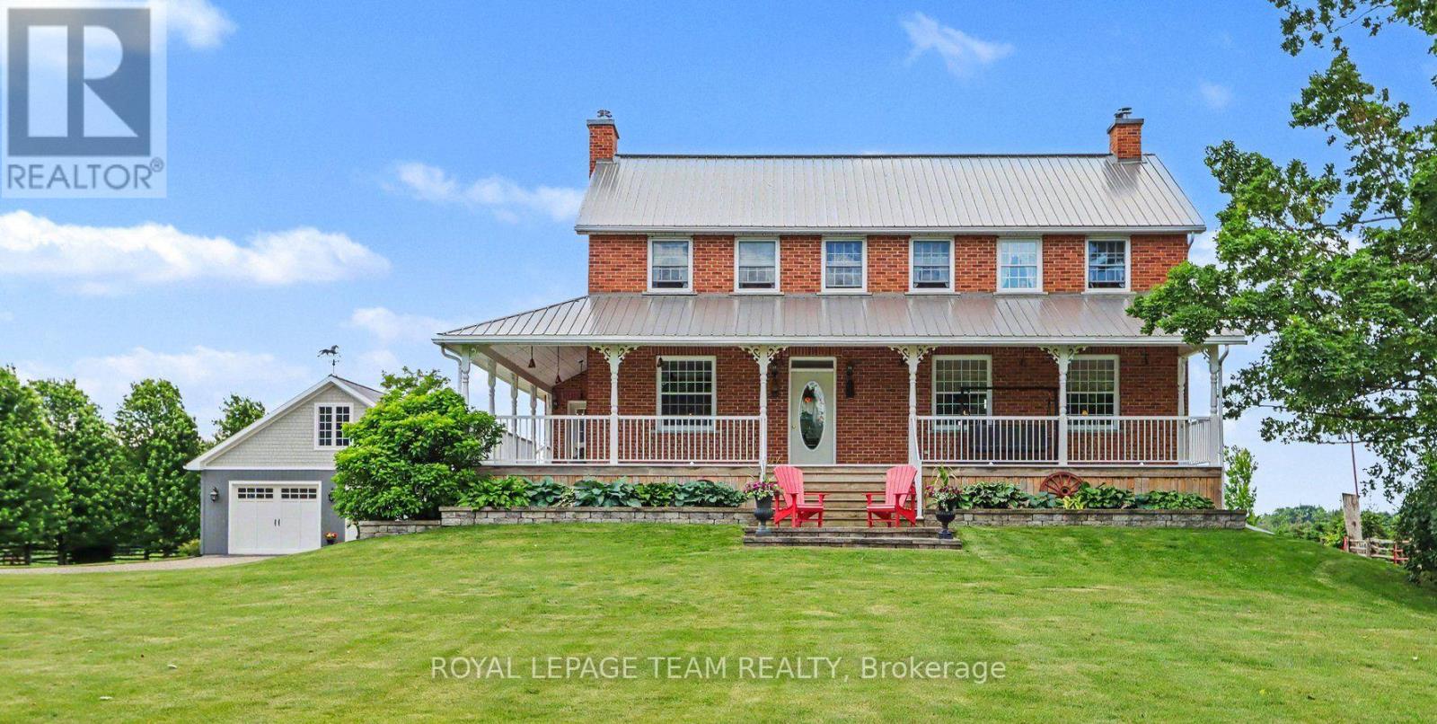 Rare opportumity to own a truly one-of-a-kind country estate where history and modern comfort blend seamlessly. Built in 2000 around an original 1776 log cabin, this remarkable 2-storey home showcases exceptional craftsmanship and timeless character at every turn. Thoughtfully designed with specially sourced red brick to preserve its historic ambiance, the home is wrapped in a welcoming veranda that invites you to relax in the peaceful surroundings. Inside, stunning wide-plank pine floors, massive exposed wood beams, and an impressive fireplace--crafted from the original foundation stone--create a warm and inviting atmosphere. A recently added four-season sunroom offers panoramic views of the property and provides the perfect space to enjoy every season. The heart of the home is the beautifully designed kitchen, where the original cabin has been seamlessly incorporated, creating a unique blend of old-world charm and modern functionality.The second level continues the home's character with wide-plank pine flooring throughout. The spacious primary suite features a walk-in closet and private ensuite, while two additional generously sized bedrooms and a well-appointed 4-piece bathroom with soaker tub complete the upper level. The fully finished basement offers additional living space with 9-foot ceilings, a large family room with gas fireplace, a fourth bedroom, full bathroom, and a versatile den. Additional features include the high performance ICF foundation and 200-amp electrical service. Set on 4.6 acres, the grounds are beautifully landscaped with mature gardens and offer outstanding outbuildings for hobbyists, entrepreneurs, or those seeking extra storage. The  35' x 80' barn provides endless possibilities, while the 30' x 30' detached garage features 8' x 10' doors, a 100-amp panel, and a loft area. Ideally located just minutes from Iroquois and the St. Lawrence River, you'll enjoy easy access to a public beach, marina, and the historic locks. (id:48254)