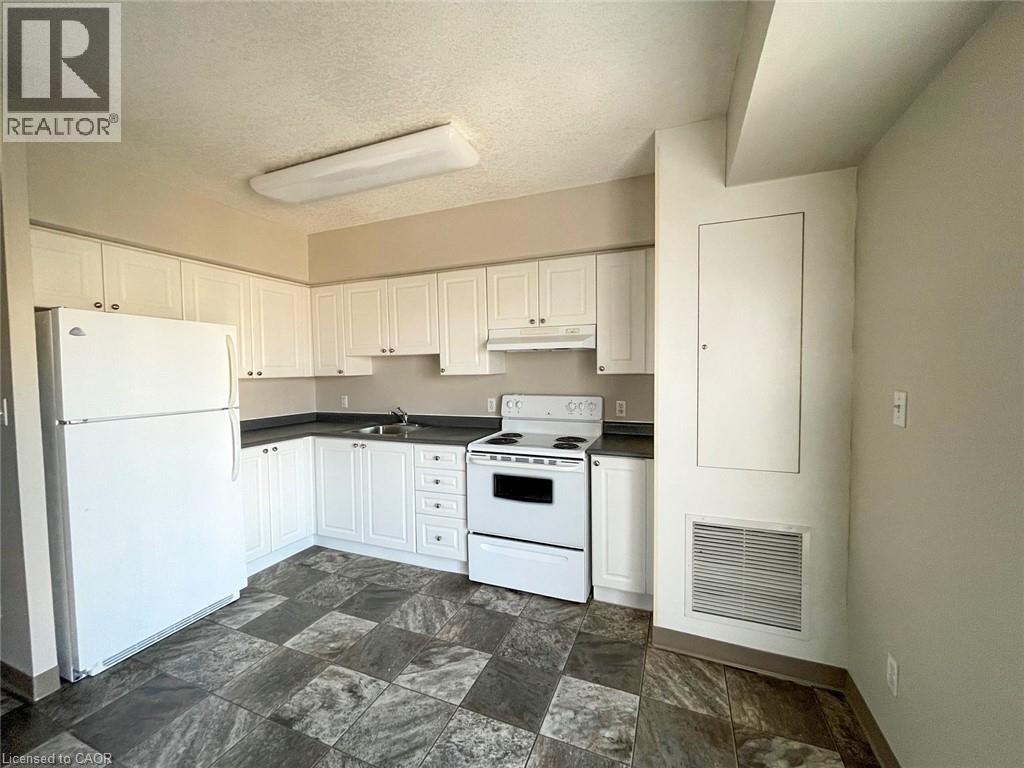 Kitchen featuring white cabinetry, dark countertops, a white refrigerator, and a white electric range