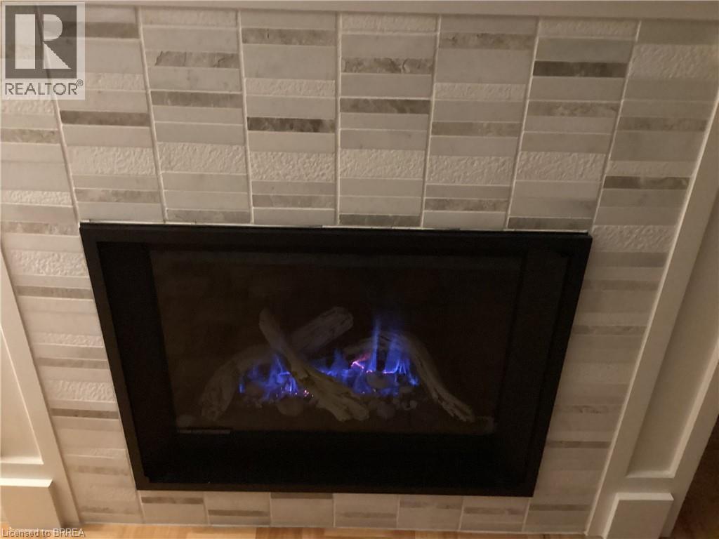 Fireplace with stone tile surround, integrated gas logs, and black trim