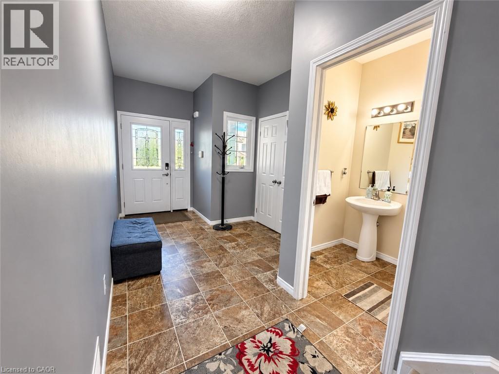 Entryway featuring tile flooring, a front door with decorative glass, and a window with white trim