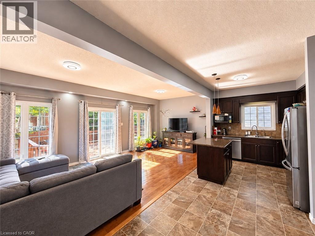 Kitchen with dark wood cabinetry, stainless steel appliances, and a central island with a granite-style countertop