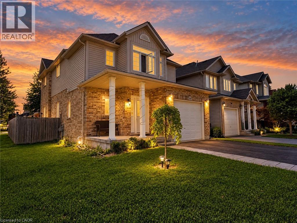 Brick and siding exterior, columned front porch, attached garage, paved driveway, and manicured lawn