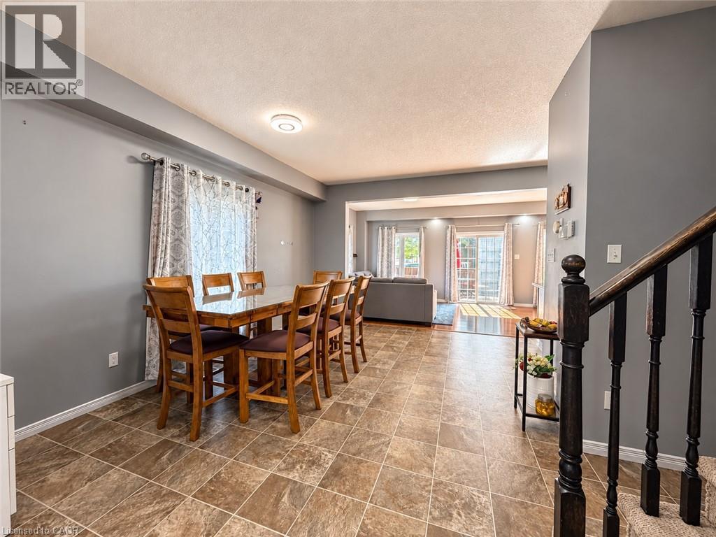 Spacious dining area with tiled flooring, recessed lighting, and direct access to a living area with sliding glass doors