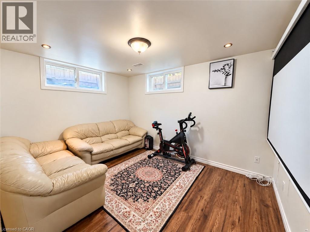 Recessed lighting, wood-finish flooring, and white walls, two windows with white trim, and a ceiling-mounted light fixture