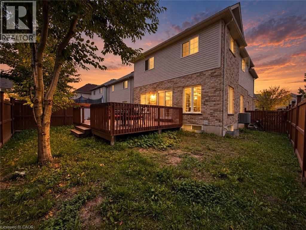 Raised wood deck with built-in steps, brick and siding exterior, and fenced perimeter