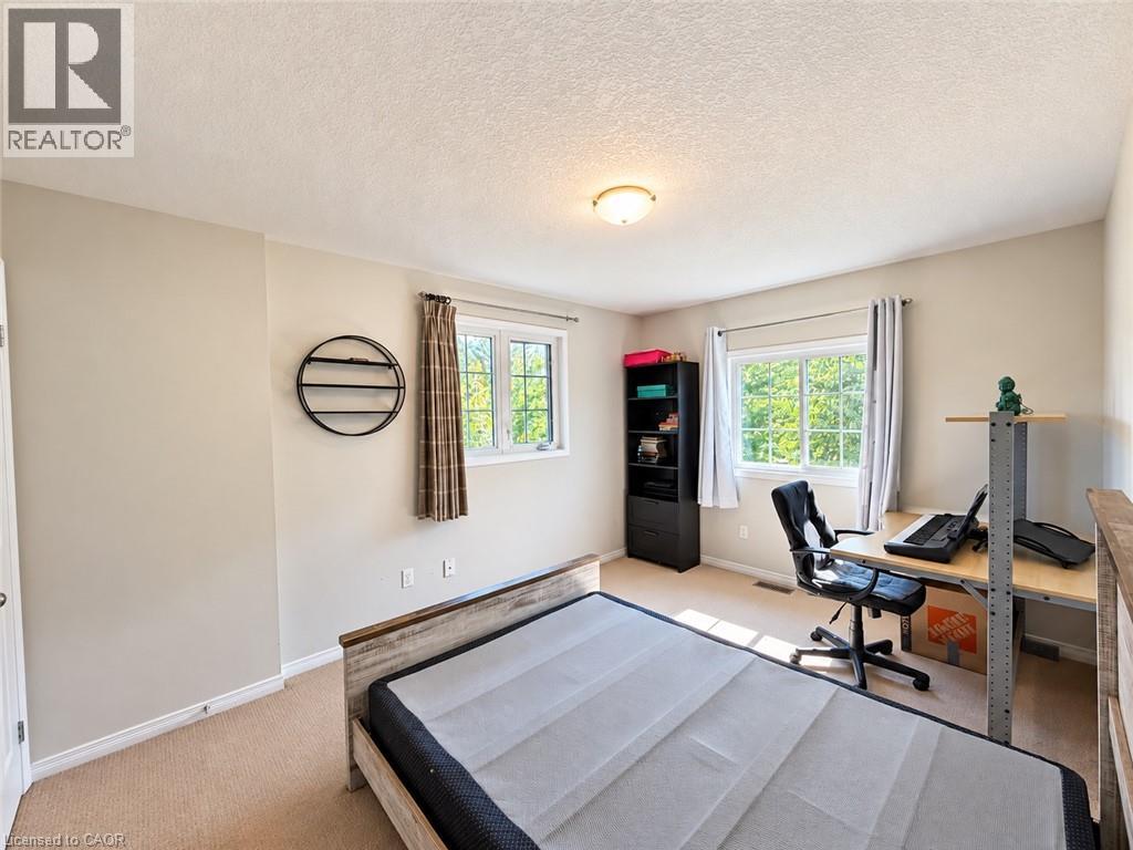 Carpeted flooring, two windows, ceiling-mounted light fixture, and neutral wall paint