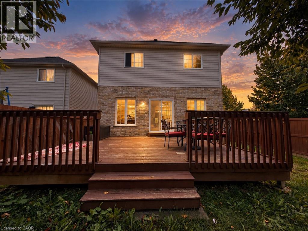 Expansive wood deck with stairs, featuring a privacy fence and siding exterior with brick detailing