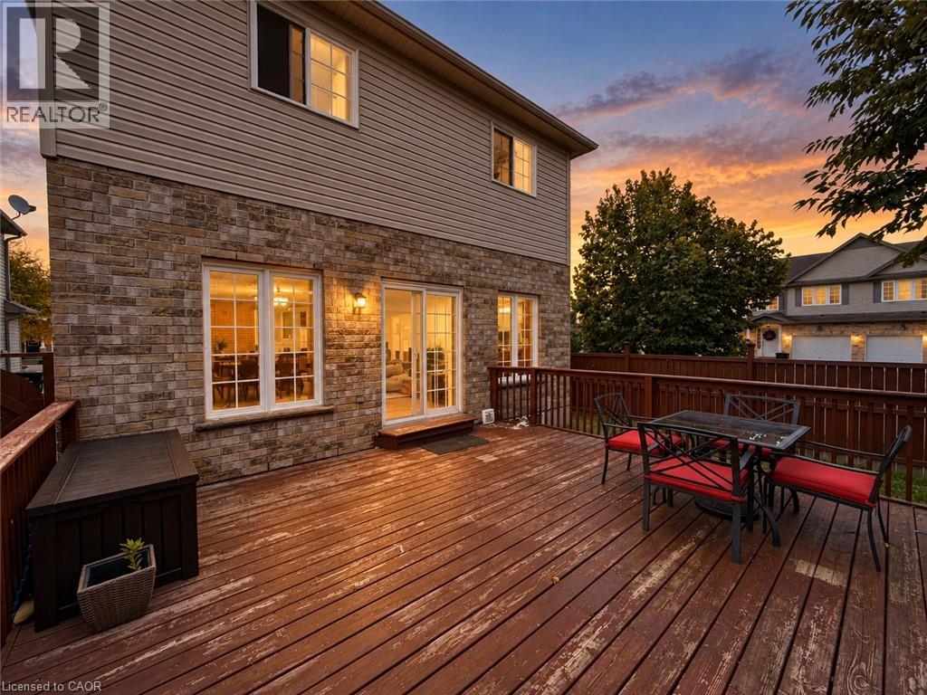 Expansive wood deck with a full-height wood railing, brick and siding exterior, and sliding glass door access