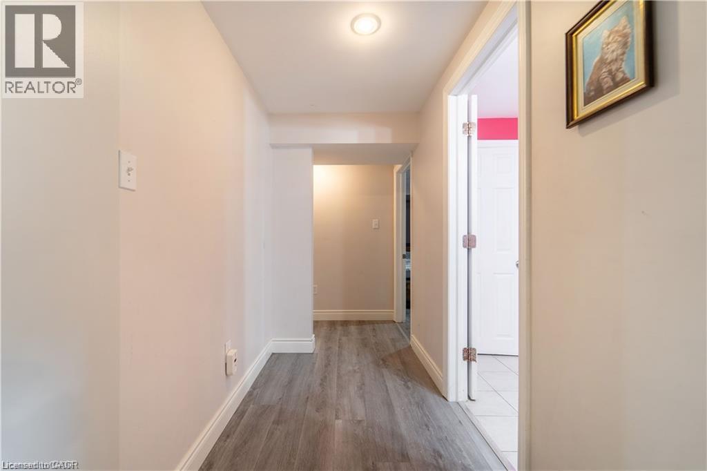 Hallway featuring wood-finish flooring, recessed ceiling lighting, and white trim