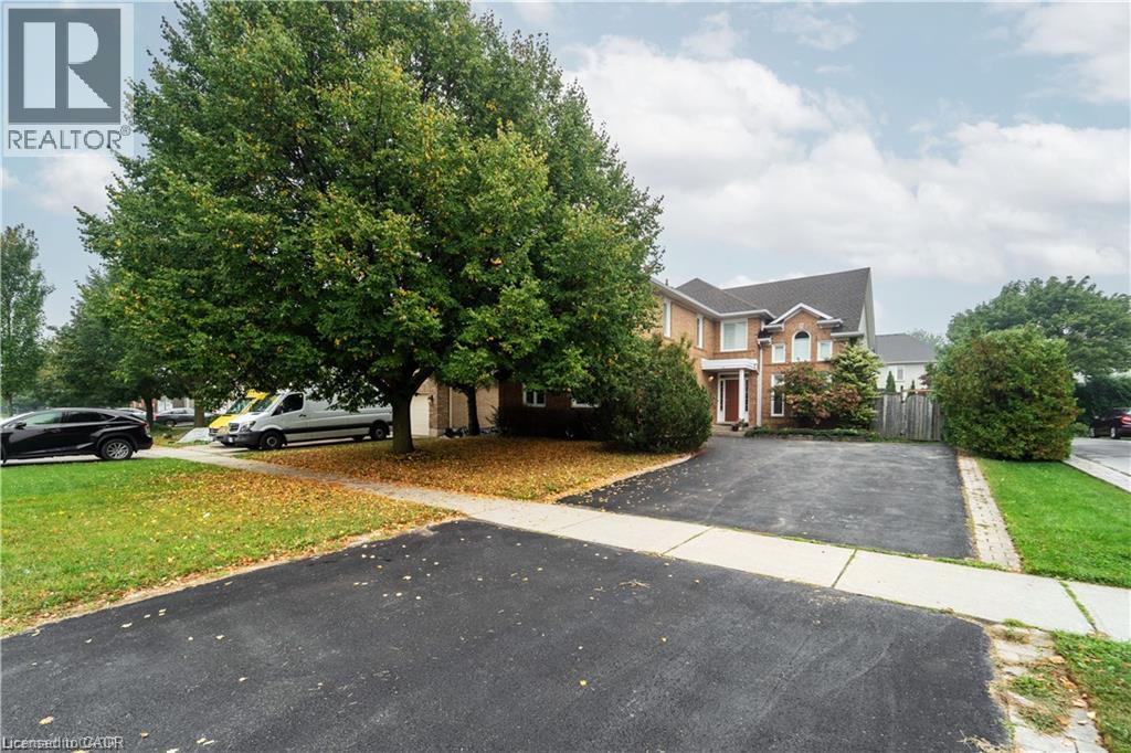 Brick exterior residence with a prominent front entrance, arched window details, and a dark asphalt driveway