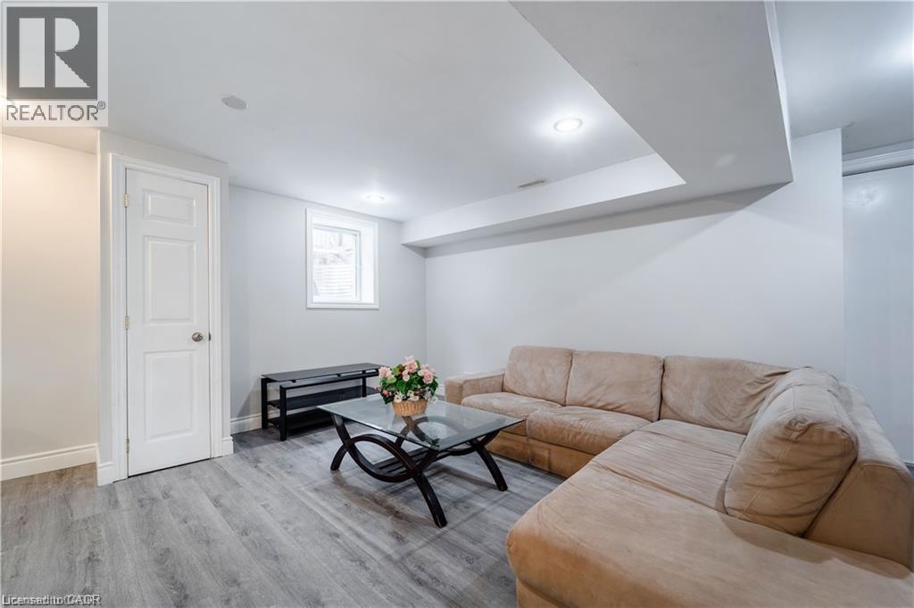 Recessed lighting, wood-finish flooring, white walls, and a white interior door with paneling