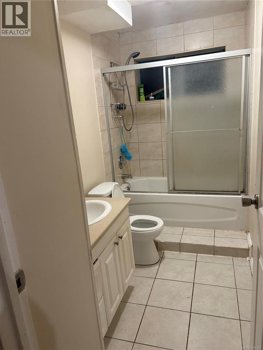 Bathroom in the lower suite with tub/shower combo and tile flooring