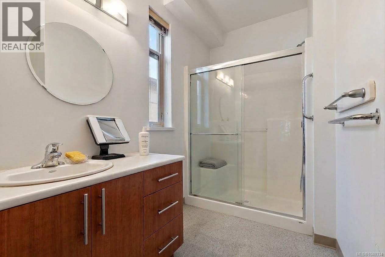 Integrated vanity with wood-finish cabinetry, solid surface countertop, and oval undermount sink
