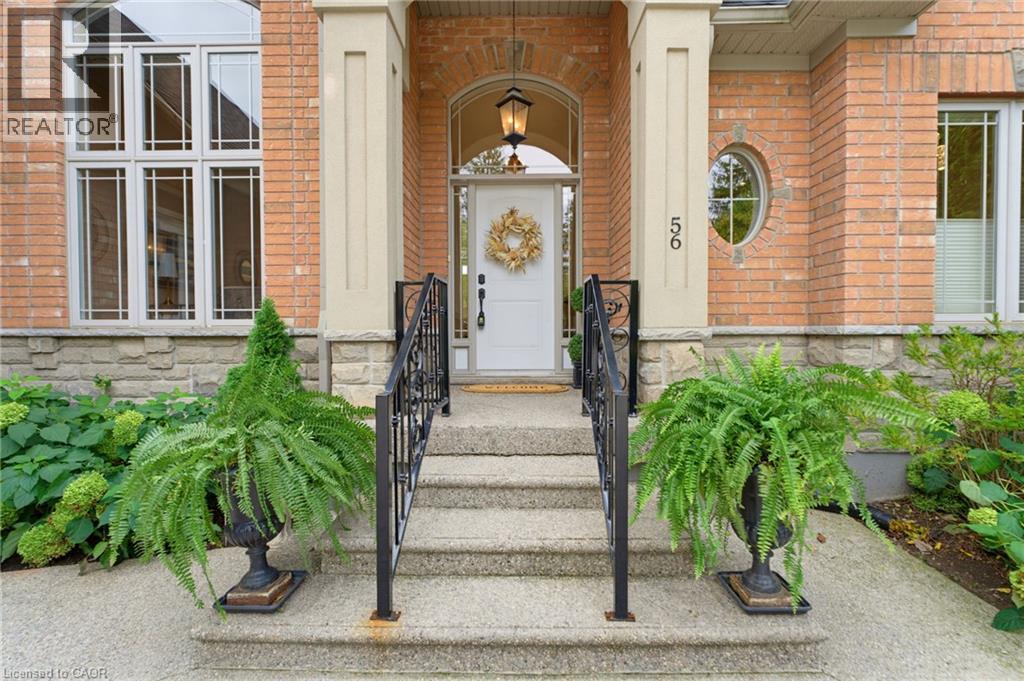 Brick exterior with stone accents, a grand entryway featuring a white door, and an arched transom window