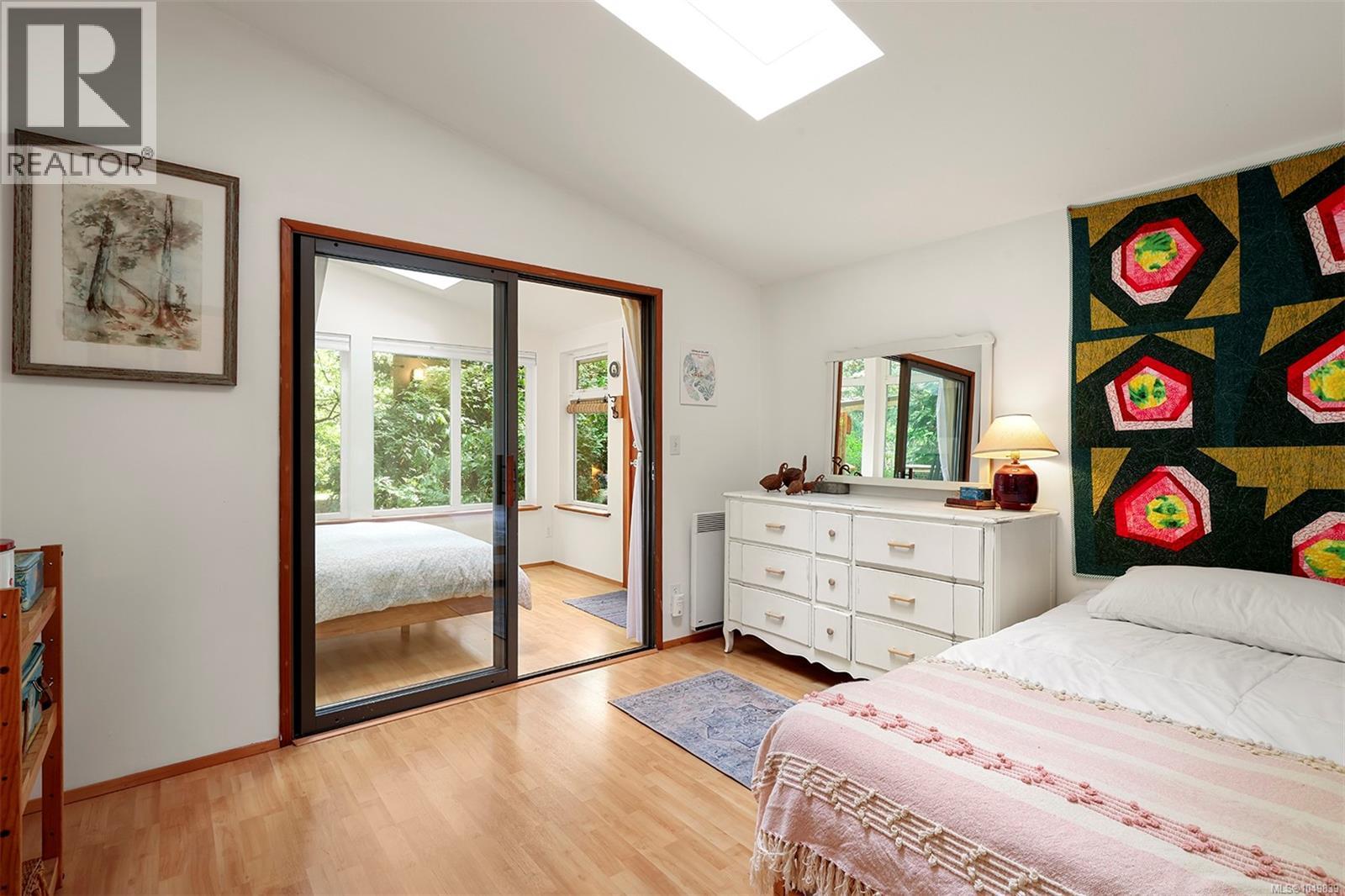Wood-finish flooring, white walls, and a vaulted ceiling