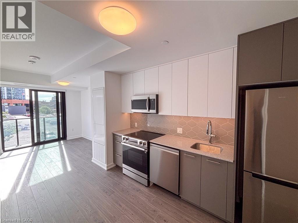 Contemporary kitchen with stainless steel appliances, stone countertops, and a mosaic tile backsplash