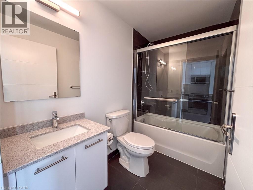 Bathroom featuring a white vanity with a light speckled countertop, under-mount sink, and chrome faucet