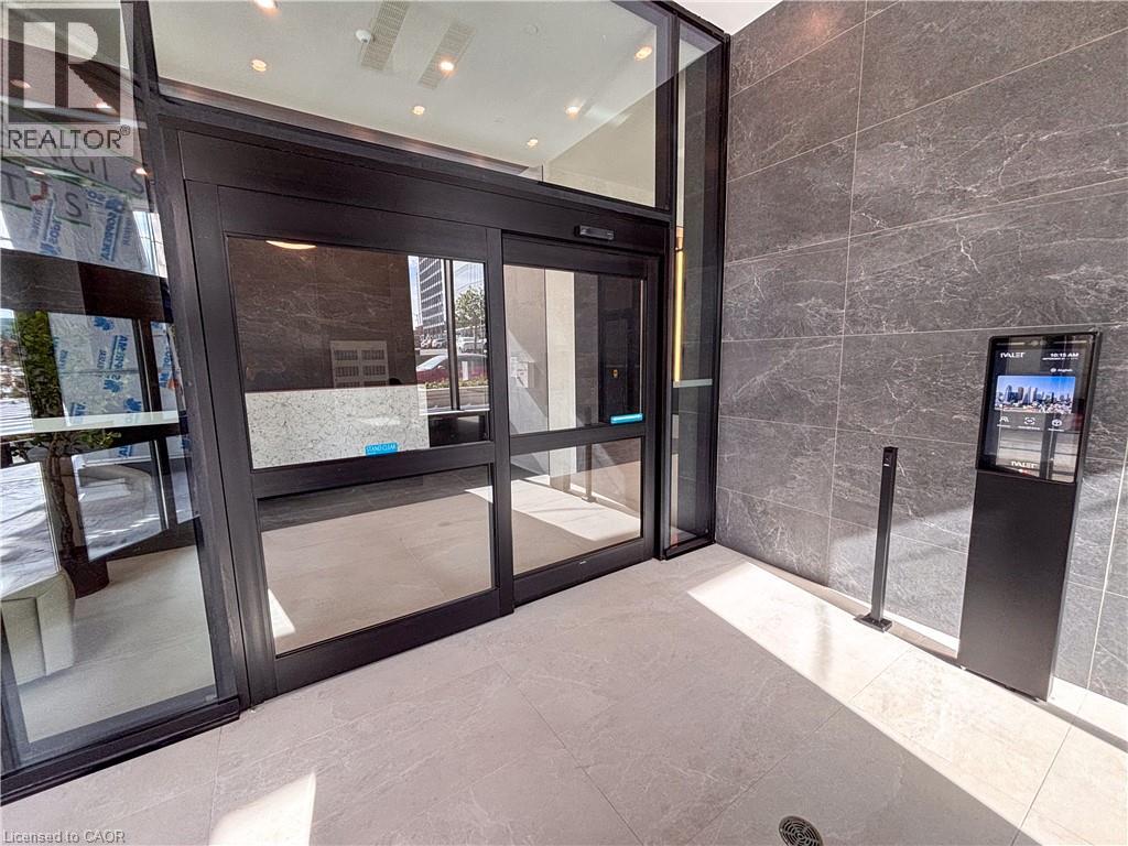 Automatic sliding glass doors, integrated digital display, recessed lighting, and textured wall paneling