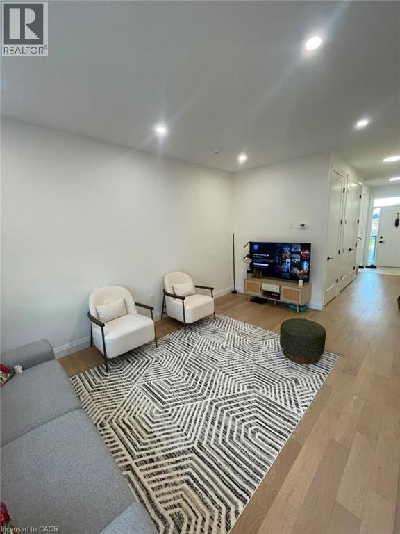 Recessed lighting throughout, light wood-finish flooring, and white interior doors