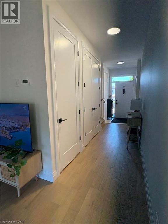 Hardwood flooring, recessed lighting, white panel doors, and black door hardware