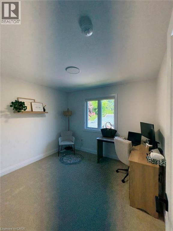 Well-lit room featuring wall-to-wall carpeting, a window with exterior tree scenery, and a floating wall shelf