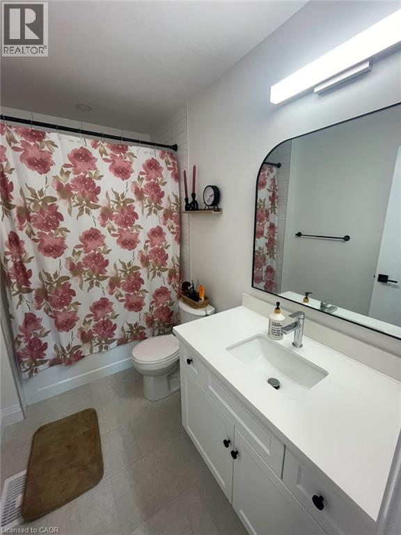 White vanity with black hardware, rectangular undermount sink, and a single-handle chrome faucet