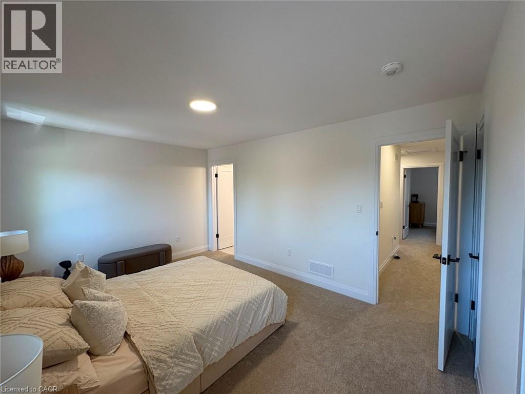Recessed ceiling lighting, white walls, light-colored carpet, white trim, and black door hardware
