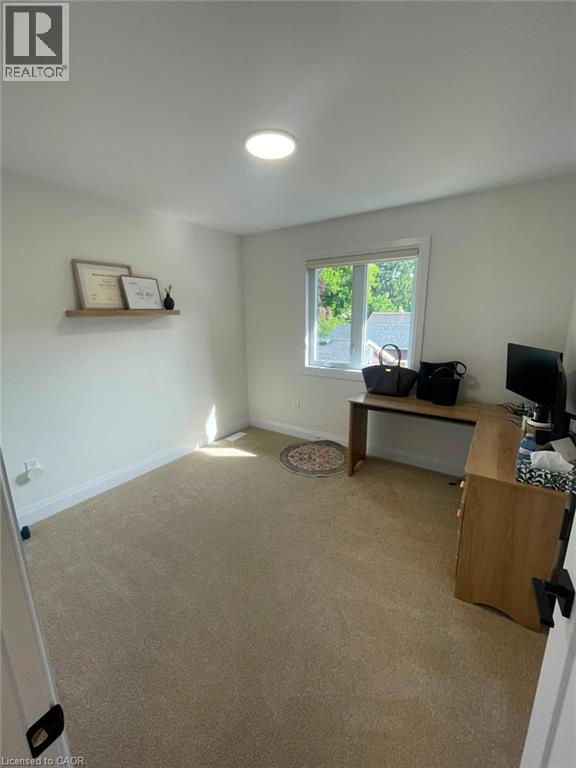 Recessed ceiling light, neutral wall paint, single-pane window, wall-mounted floating shelf, and carpeted flooring