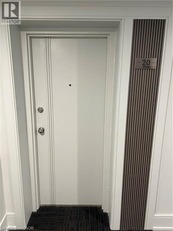 White entry door with decorative vertical paneling and brushed nickel hardware