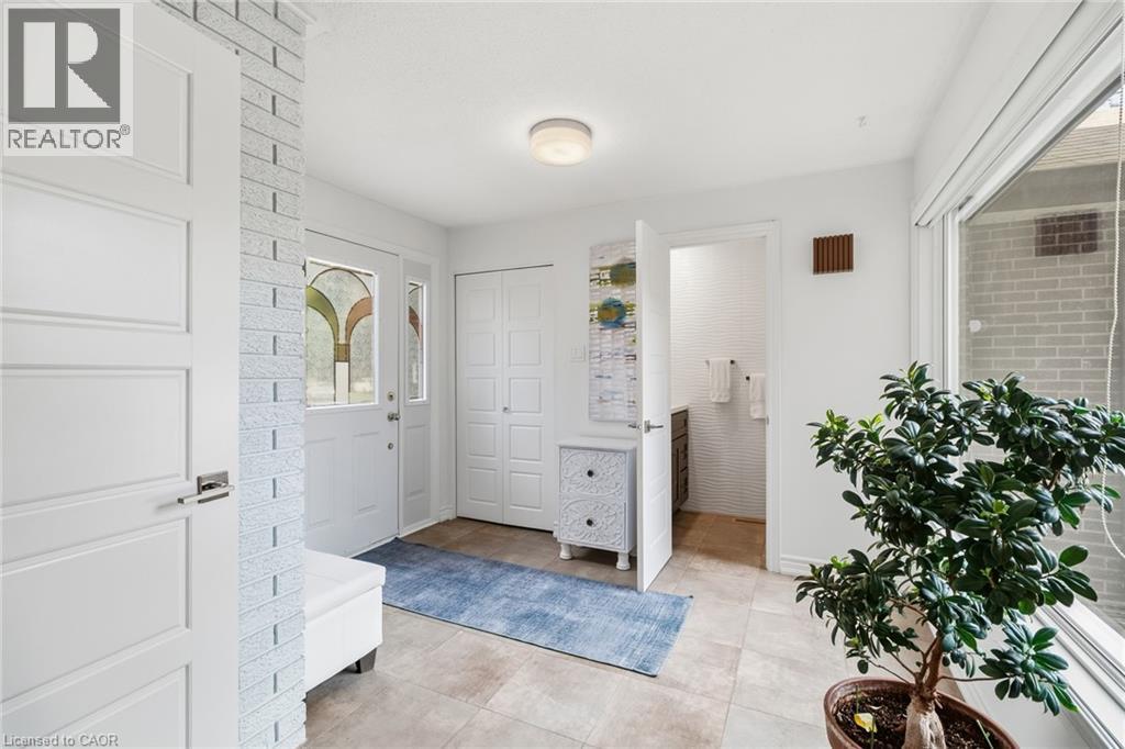 Entryway featuring tiled flooring, a front door with decorative glass, and a large window