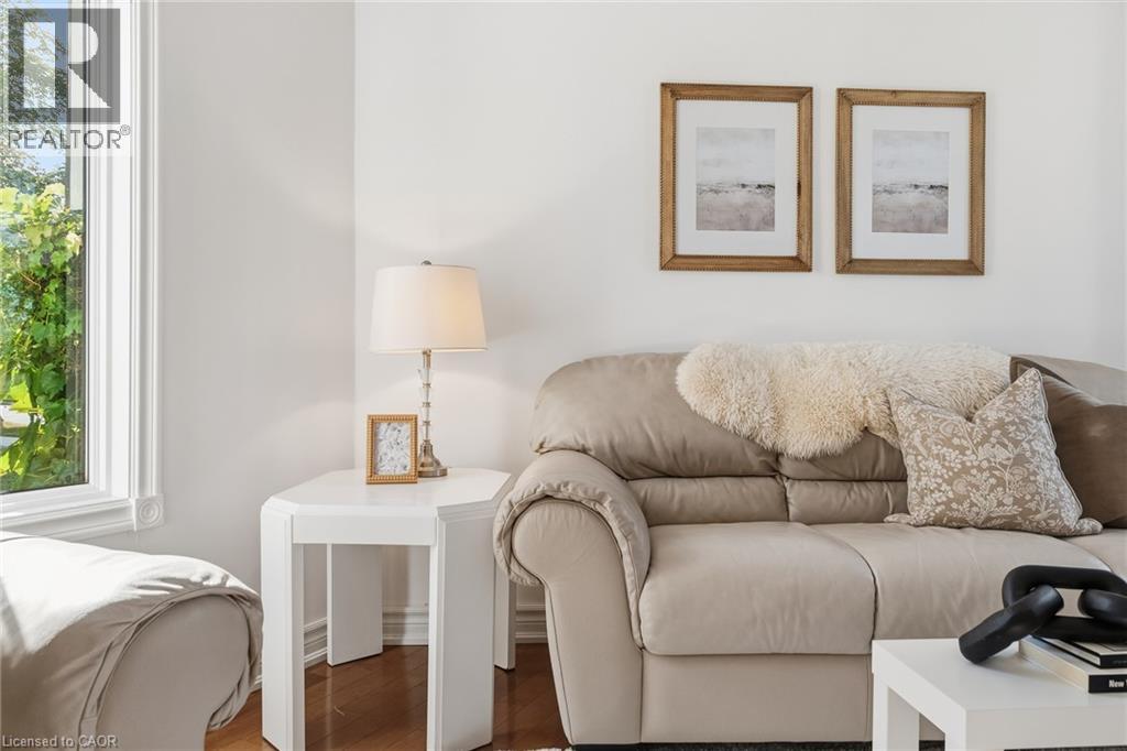 White wall finish, wood-finish flooring, white window trim, and a white side table