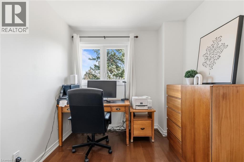 Hardwood-finish flooring, white painted walls, and a multi-pane window