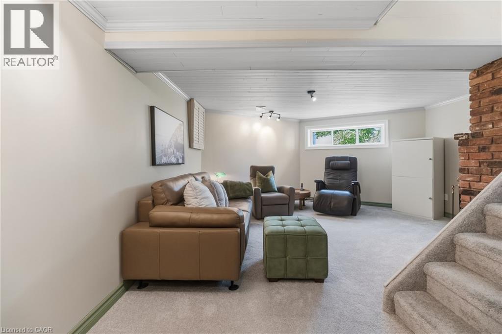 Carpeted flooring, exposed brick wall, white painted ceiling with wood planks, recessed lighting, and a horizontal window