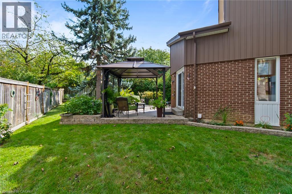 Expansive lawn area with a raised garden bed and a stone retaining wall